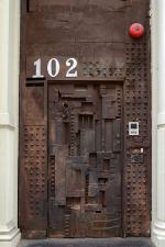 16 2 steel sculpture door at 102 greene st designed by william tarr the hook is the door knocker the barred square opens from the inside in soho new york city
